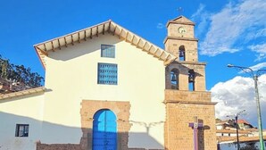 Un bâtiment doté d’une tour horlogée, d’une porte bleue et d’une petite fenêtre.