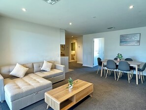 Ein modernes Wohnzimmer mit einer Couch, einem Couchtisch und einem Essbereich.