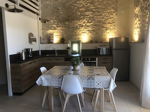 Une cuisine moderne avec une table à manger, des chaises et un réfrigérateur.