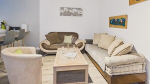 Ein modernes Wohnzimmer mit einem braunen Sofa, einem beigen Sessel und einem Couchtisch aus Holz.