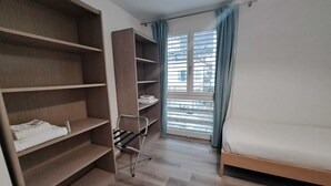A bedroom with a bed, a wardrobe, and a drying rack. - Luisiana (Minusio)