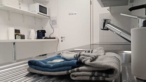 A stainless steel sink with a towel and a soap dispenser. - Luisiana (Minusio)