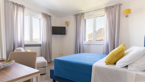 Une chambre d’hôtel avec un lit, un bureau et une chaise.