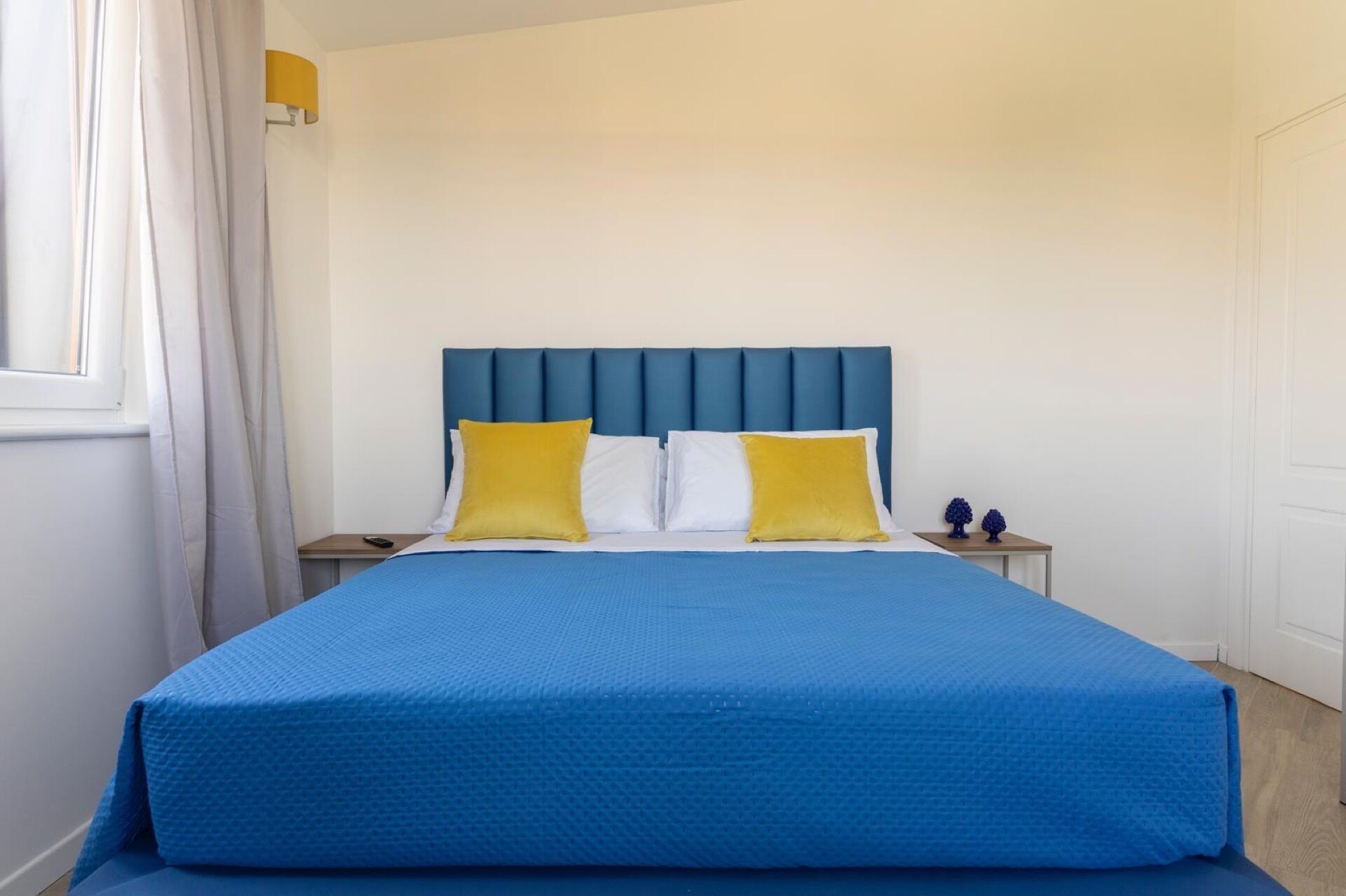 Une chambre à coucher avec un lit, deux tables de chevet et une petite table d’appoint.