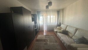 A living room with a sofa, a cabinet, and a television. - 2-bedroom apartment with AC in charming Center Râmnicu Vâlcea (Râmnicu Vâlcea)
