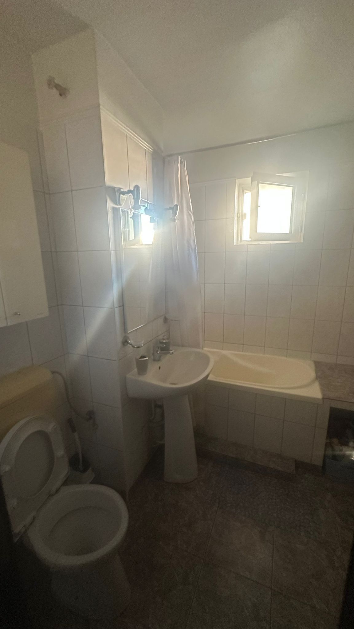 A bathroom with a toilet, sink, and bathtub.