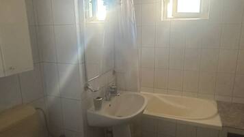 A bathroom with a toilet, sink, and bathtub.