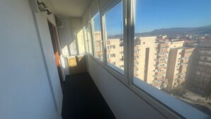 A narrow corridor with a window leading to a cityscape view. - 2-bedroom apartment with AC in charming Center Râmnicu Vâlcea (Râmnicu Vâlcea)