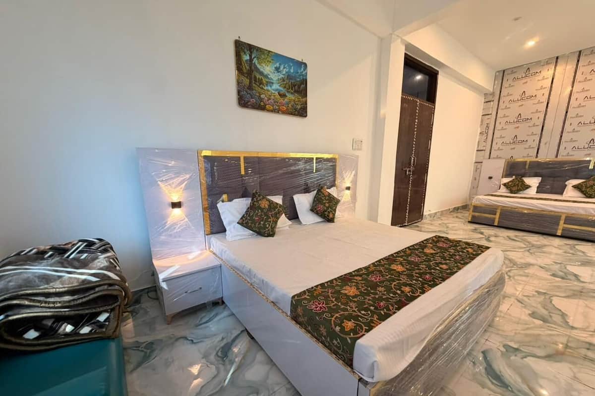 Quarto com cama, mesas de cabeceira, um quadro na parede e um banheiro visível por uma porta aberta.