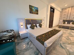 Een slaapkamer met een bed, nachtkastjes, een schilderij aan de muur en een badkamer die door een open deur zichtbaar is.