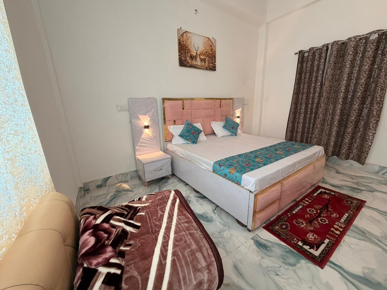 A bedroom with a bed, nightstands, a headboard, a window with curtains, and a patterned rug.