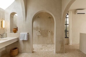 Ein geräumiges Badezimmer mit großem Bogenportal, einem weißen Handtuch an der Wand und einem Fenster für natürliches Licht.