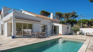 Et moderne hus med swimmingpool, overdækket terrasse og have.