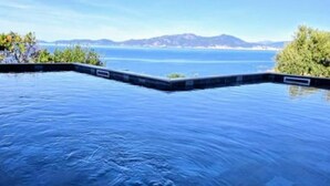 En infinitypool med en fantastisk utsikt över havet och de avlägsna bergen.