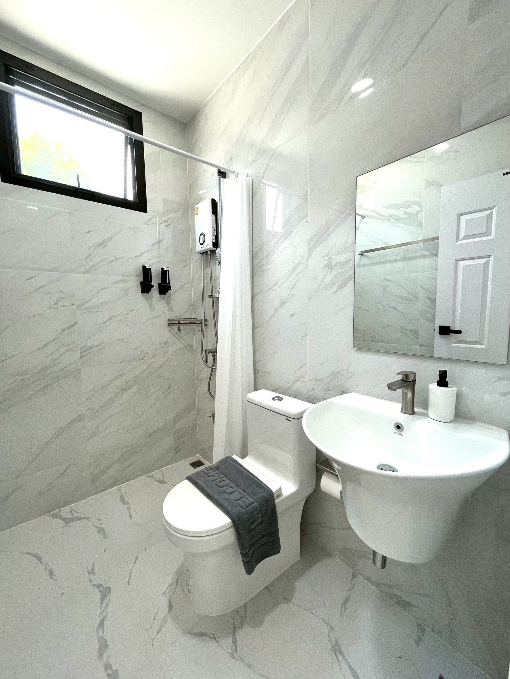 Ein modernes Badezimmer mit Toilette, Dusche und Waschbecken.