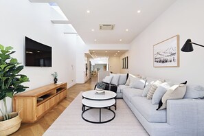 TV, fireplace, books - Architectural Redfern Gem – Designer 3BR Home with Courtyard & Loft (Redfern)