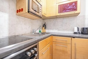 Eine Küche mit Mikrowelle, Spüle und Holzschränken.