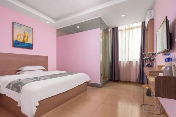A hotel room with a bed, a desk, a chair, a mirror, and a window with curtains.