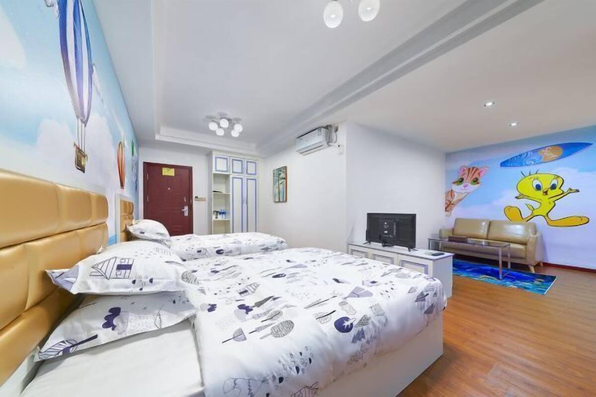 Une chambre à coucher avec un lit, une télévision, un canapé et une fresque murale.