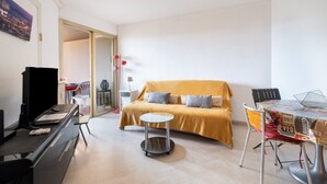 A room with a bed, a desk, a chair, and a small table. - “Le Rose Garden” Apartment with Balcony, Wi-Fi, and Air Conditioning (Cagnes-sur-Mer)