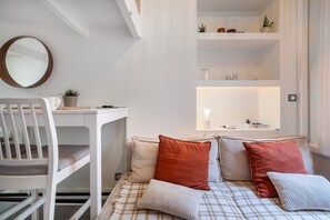 A modern room with a bed, a white desk, and a mirror. - Charming Studio in the Heart of Nice with Wi-Fi and Air Conditioning (Nice)