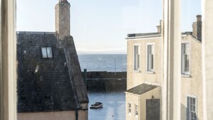 En vy över ett kustområde med byggnader, en vattenyta och en båt.