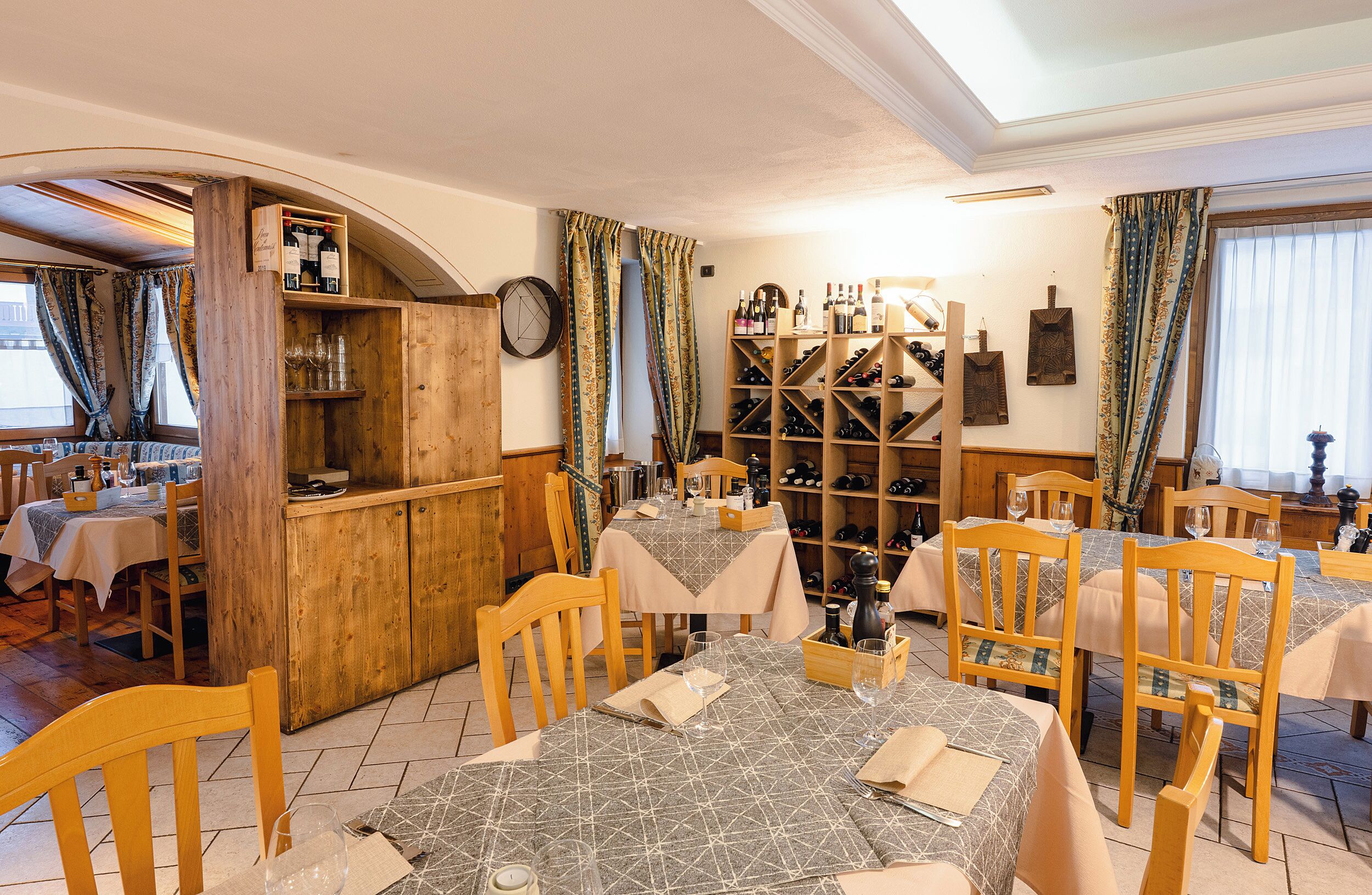 Ein Restaurant mit Holzmöbeln, Weinregalen und einer gemütlichen Einrichtung.