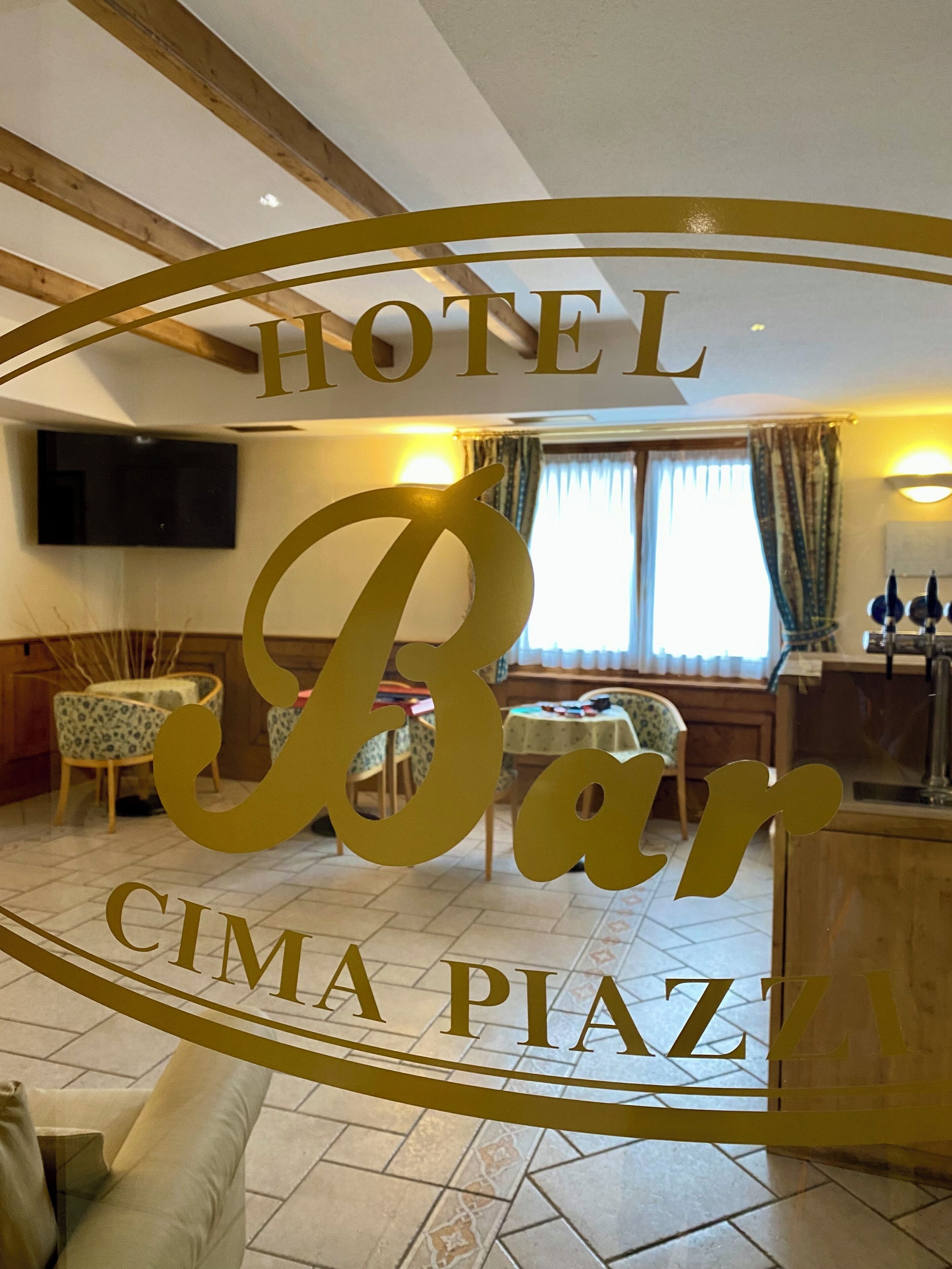 Un bar de hotel con un cartel grande que dice "HOTEL Bar Cima Piazza".