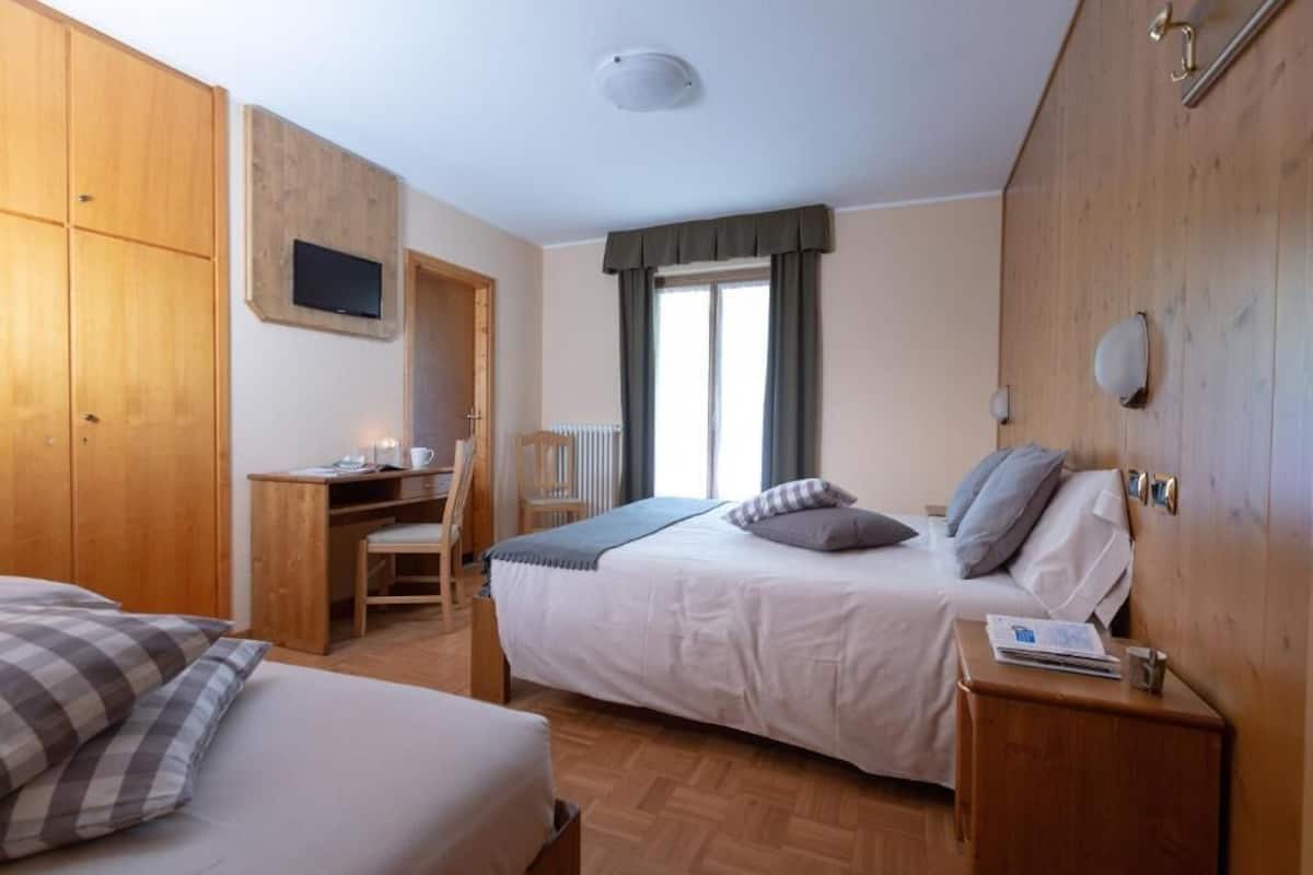 Un dormitorio con dos camas, un escritorio y una silla.