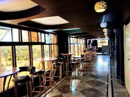Un restaurante con una barra larga, sillas y mesas.