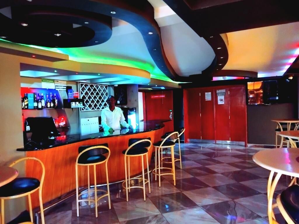 A bar area with a counter, stools, and a checkered floor.