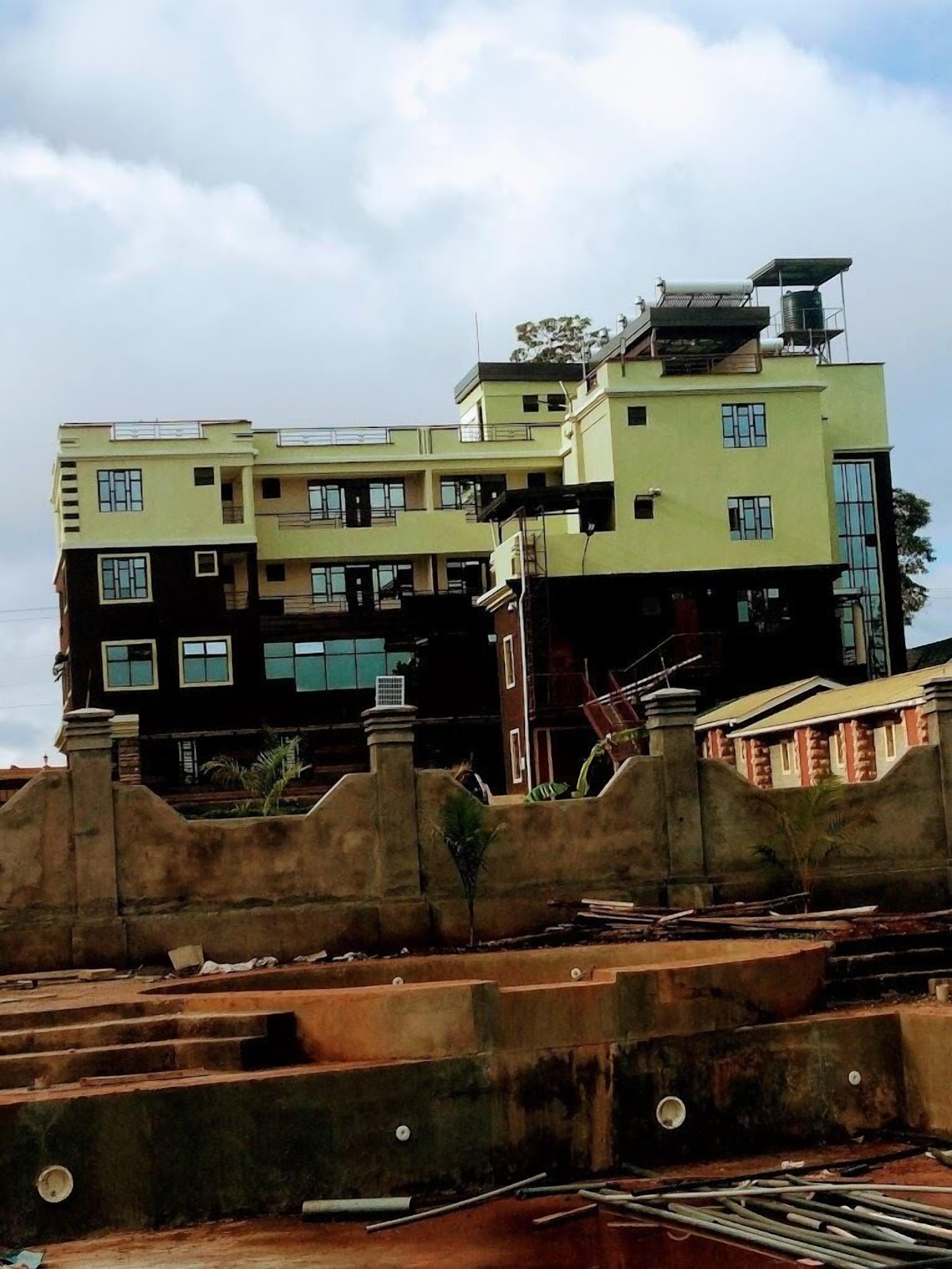 A multi-story building with a flat roof and a water tank on the roof.