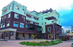 Un edificio de varios pisos con un diseño arquitectónico moderno, con balcones y ventanas grandes.