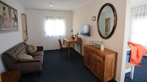 A room with a sofa, a desk, a television, a mirror, and a cabinet. - Jezera Island Hideaway in Adriatic Sea (Tisno)