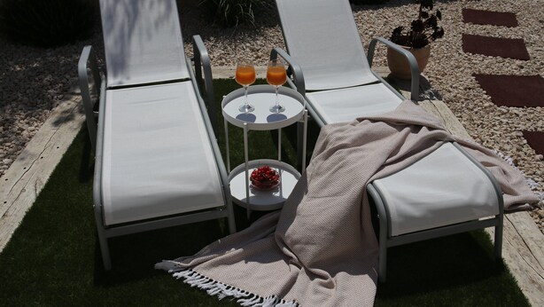 Two lounge chairs with white cushions, a small round table with two glasses of orange juice, and a potted plant. - Jezera Island Hideaway in Adriatic Sea (Tisno)