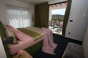 A bedroom with a bed, a small table, and a balcony with a view. - Jezera Island Hideaway in Adriatic Sea (Tisno)