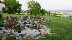 A garden with a pond, rocks, and statues.