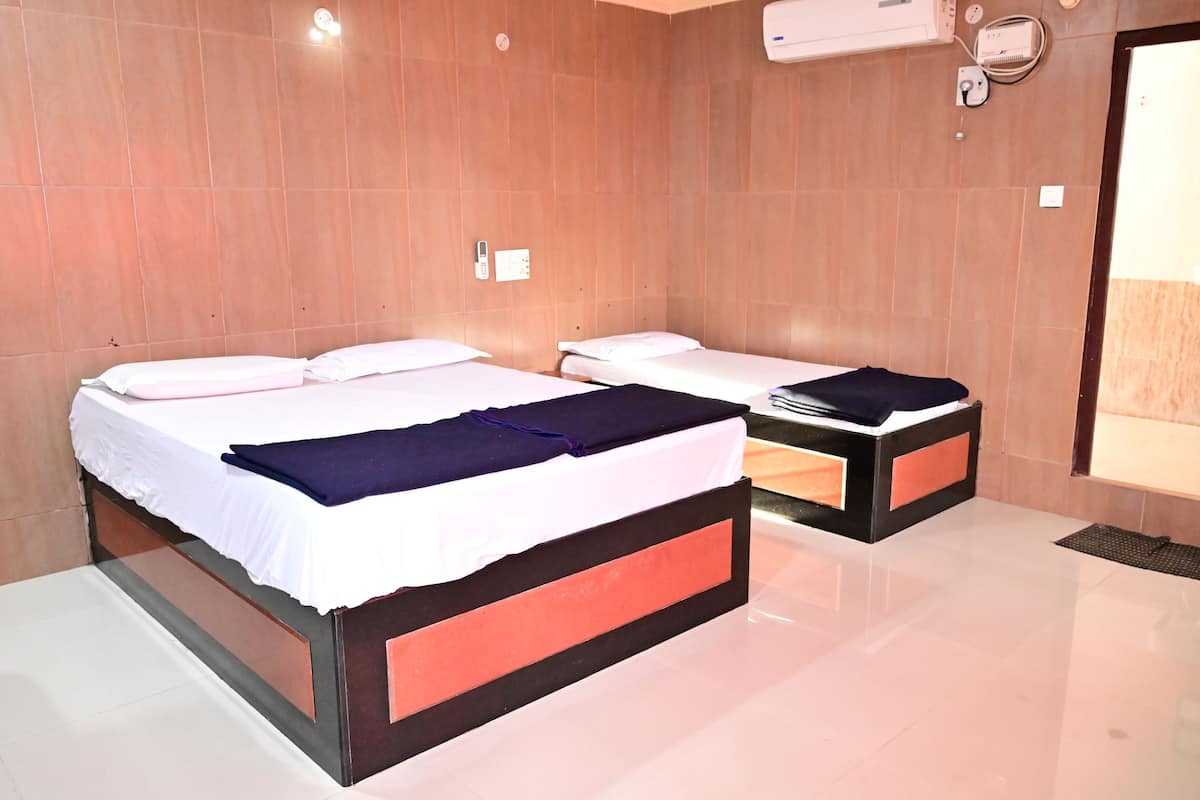Une chambre d’hôtel avec deux lits, un miroir, un climatiseur fixé au mur et une porte donnant sur un balcon.