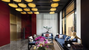 A modern living room with a sofa set, a coffee table with a floral centerpiece, and a gramophone. - The Yun Collection  Yongqingfang  (Guangzhou)