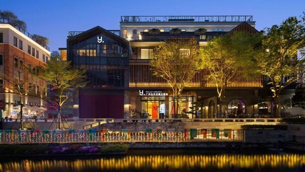 A modern building with a prominent 'Y' logo, a glass facade, and a reflection in the water. - The Yun Collection  Yongqingfang  (Guangzhou)