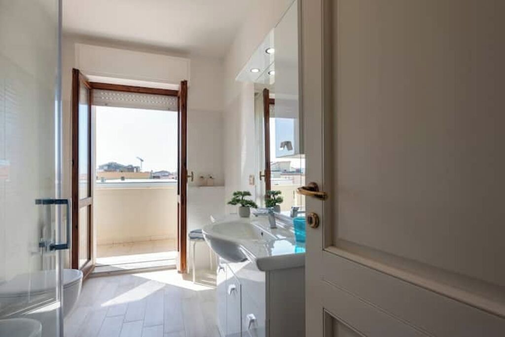 Une salle de bain moderne avec une grande fenêtre, un lavabo et un miroir.
