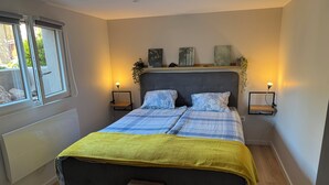 A bedroom with a bed, bedside tables, and a window. - New, modern apartment • Comfort - Parking (Sundhoffen)