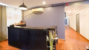 A reception area with a dark counter, a wall-mounted air conditioner, and a pendant light. - Ramayan Inn Hotel (Lucknow)