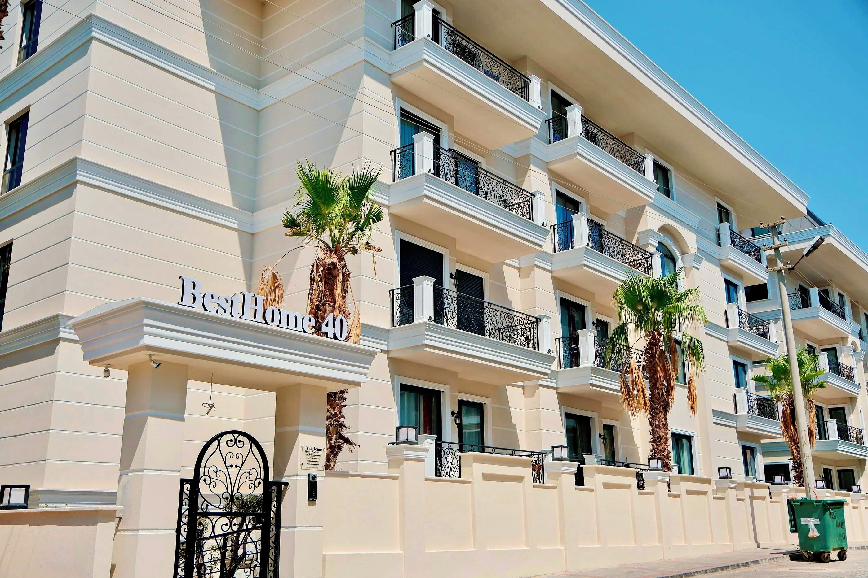 A multi-story hotel with balconies and palm trees.