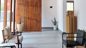 A modern interior with a wooden ceiling, a sliding wooden partition, and a seating area with a table and chairs. - The Zen Punakha (Punakha)