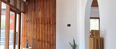 Un interior moderno con techo de madera, un panel corredizo de madera y una zona de estar con mesa y sillas.