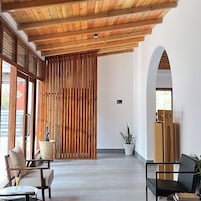 Un interior moderno con techo de madera, un panel corredizo de madera y una zona de estar con mesa y sillas.