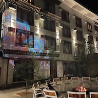 Exterior de un hotel con patio, asientos al aire libre y una chimenea.