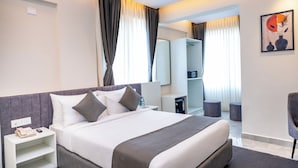 A hotel room with a bed, bedside table, nightstand, wardrobe, and a mirror. - U By Z Hotels, Brookefield (Bengaluru)