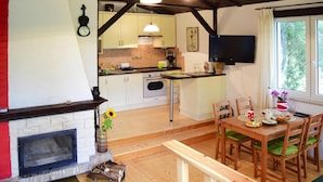 Une cuisine avec une cheminée, une table à manger en bois et des chaises.